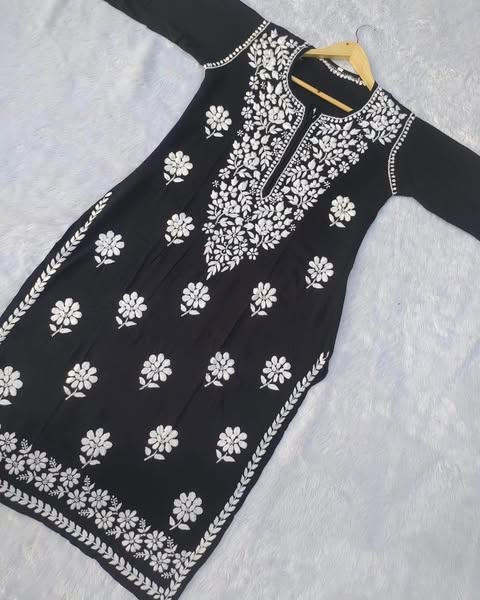 Black dress with white floral embroidery on a light gray background
